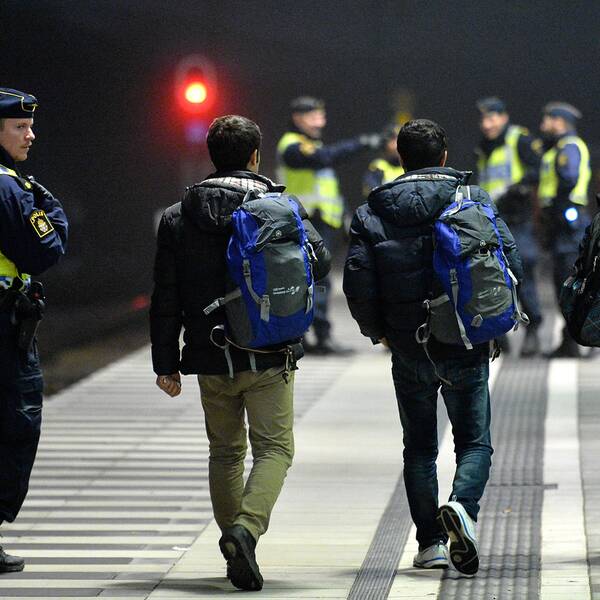 Polis eskorterar asylsökande från ett Öresundståg som stannat vid Hyllie station utanför Malmö efter genomförd gränskontroll.