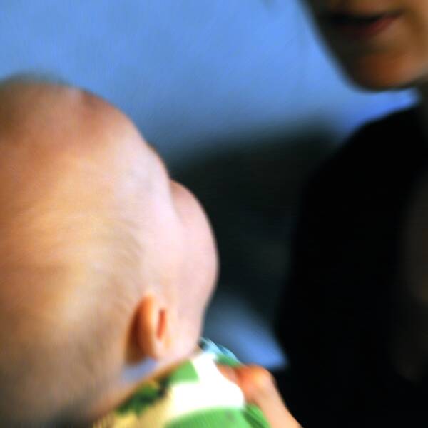 En kvinna håller i en bebis.