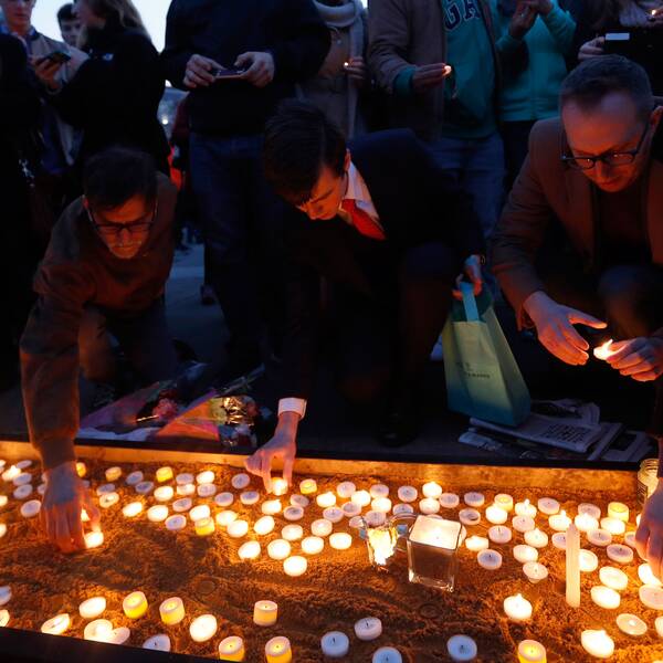 Människor hedrar offren i attacken, tänder ljus