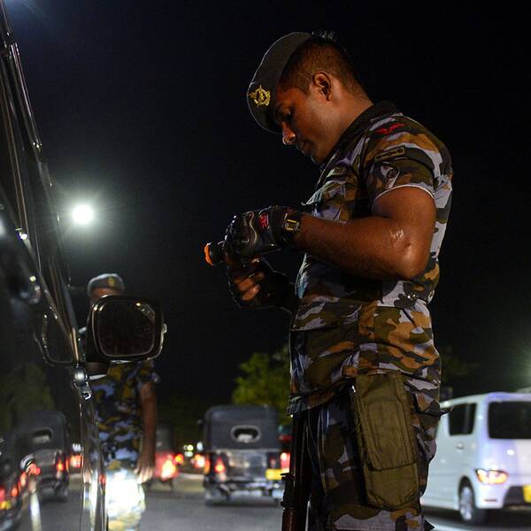 Säkerhetspersonal kontrollerar en bil vid en vägspärr i Colombo.