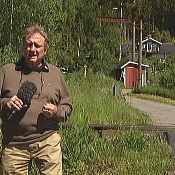 Reporter Kjell Lundström står framför en obevakad järnvägsövergång