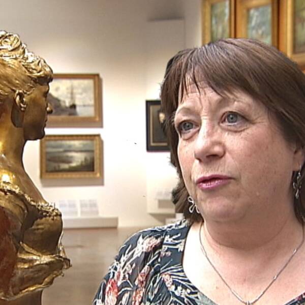en medelålders kvinna som intervjuas inne på museum