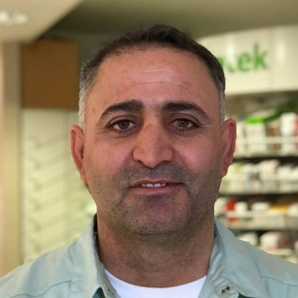 Ali Darwish framför hyllor med mediciner