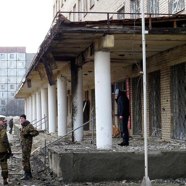 Proryska separatist-soldater framför det sjukhus i Donetsk som träffades av artillerield.