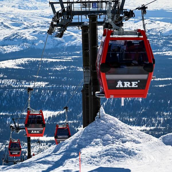 Arkivbild över en skidlift i Åre med röda kabiner med texten Åre. Snö.