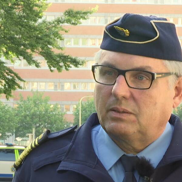 en medelålders man i polisuniform intervjuas utomhus