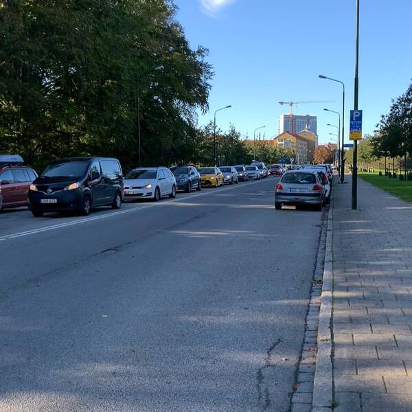 Bilden visar en lång bilkö längs Pildammsparken i Malmö.