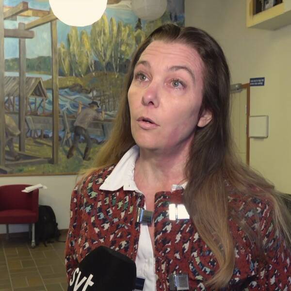 Carolina Ardesjö Lundén i röd kofta med svart och vitt hundtandsmönster.