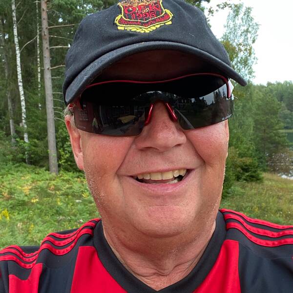 man i svarta solglasögon, ÖFK-keps, rödsvart ÖFK-tröja, ute i skogsmiljö