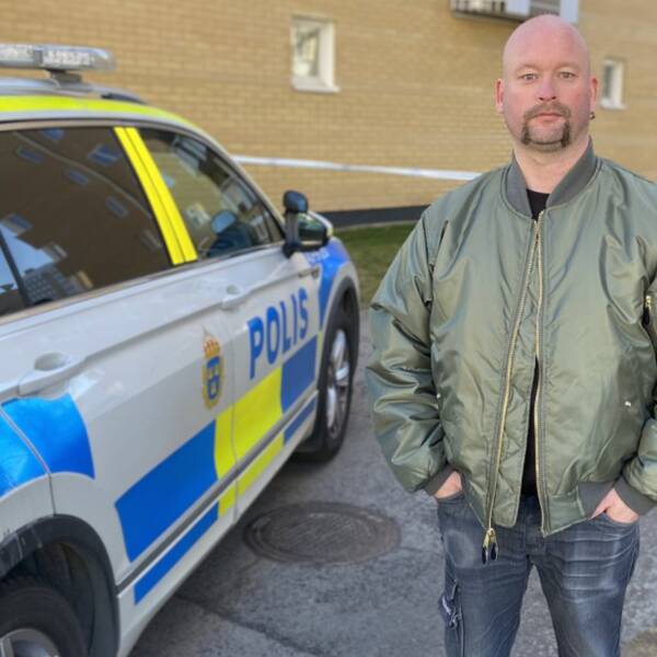 Tommy Sjögren står bredvid en polisbil. I bakgrunden syns avspärrningsband.