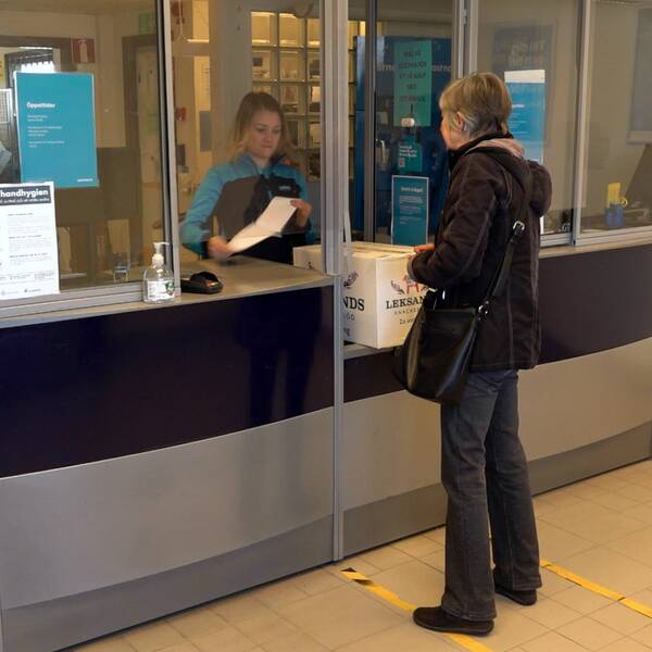 En kvinna lämnar in ett paket på Postnords Företagscentrum. 