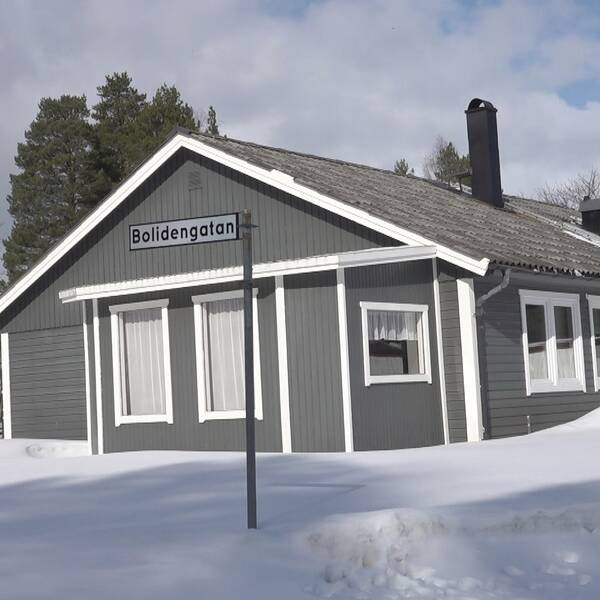 en grå enplansvilla i trä, snötäckt markt