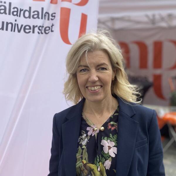 Helena Jerregård, vice rektor på Mälardalens universitet, framför universitetsflagga på stora torget i Västerås.
