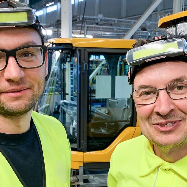Två män i glasögon och arbetskläder. 