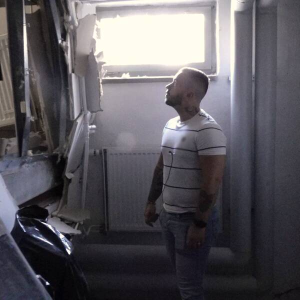 Bild på Johan Burén, fastighetsförvaltare på Strängnäs Bostads AB, som står i ett källarutrymme och tittar upp mot en bortsprängd vägg.