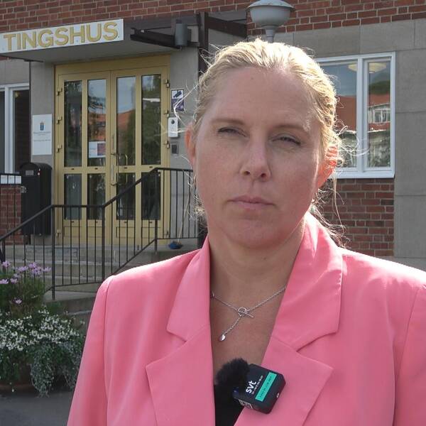 Advokat Carolina Holmberg i rosa kostym utanför tingshuset.