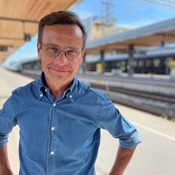 Moderaternas partiledare Ulf Kristersson står på en tågperrong.
