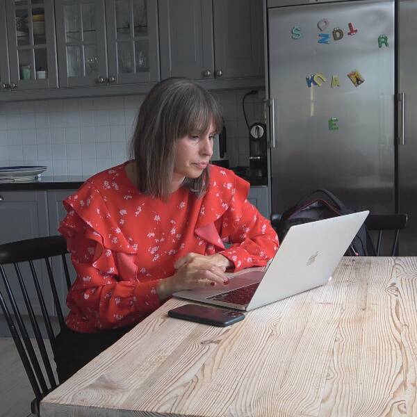Liza Lundberg sitter framför datorn i sitt kök