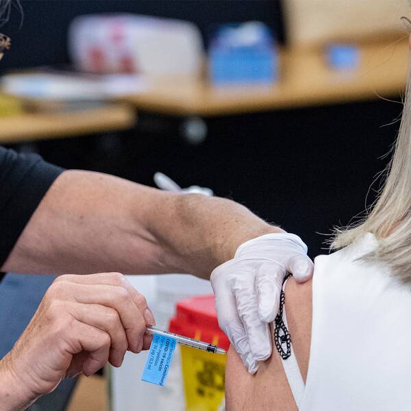 En ung kvinna blir vaccinerad av en äldre kvinna.