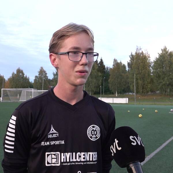 en ung kille intervjuas på en fotbollsplan utomhus
