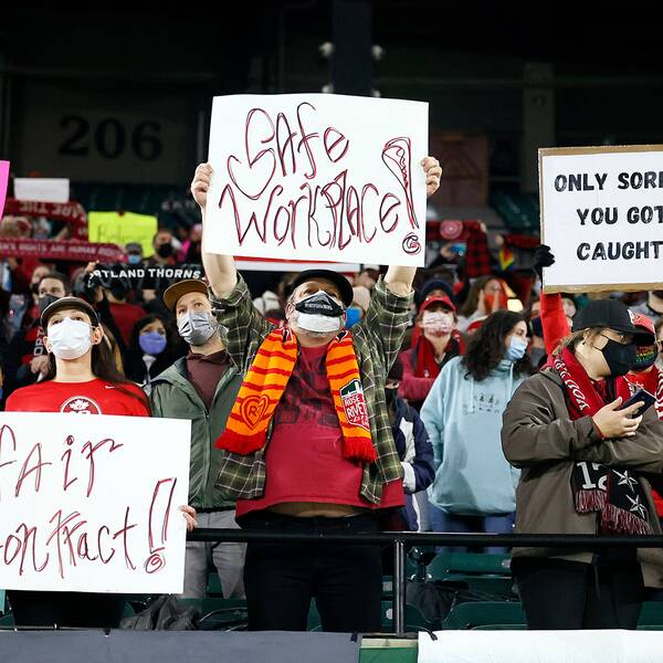 Fans som håller upp skyltar under matchen Houston Dash – Portland Thorns FC.