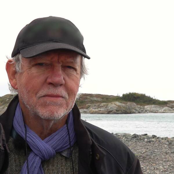 Christer Haagman i svart keps framflr stenig strand
