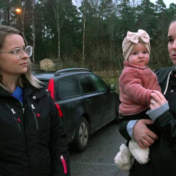 Föräldrarna Emma och Annie, Annie håller en liten bebis i famnen.