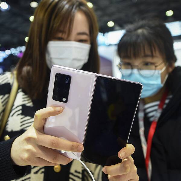 Två kvinnor som kollar in en ny Huawei-telefon.