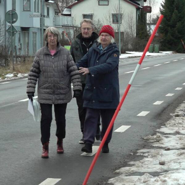 Två kvinnor och en man, boende i Ambjörb, går på vägen för att gång- och cykelvägen är försenad.