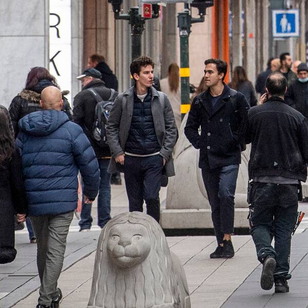 Massor av människor promenerar på shoppingstråket på Drottninggatan i Stockholm.