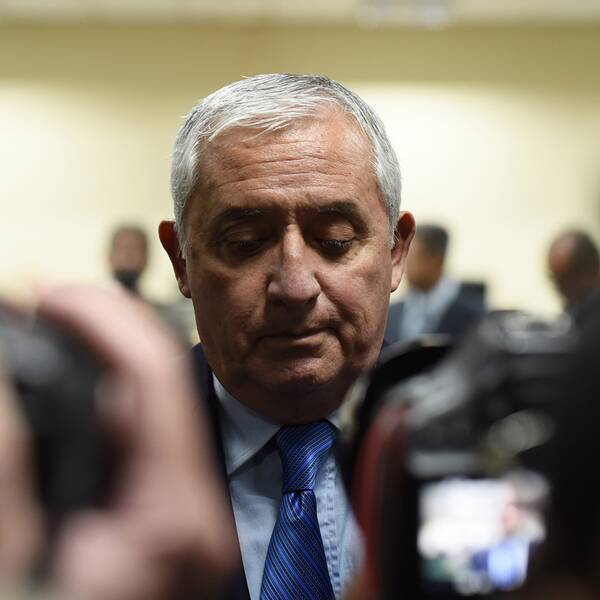 Otto Pérez Molina, Guatemalas tidigare president. Han tittar ner framför flera fotografer.