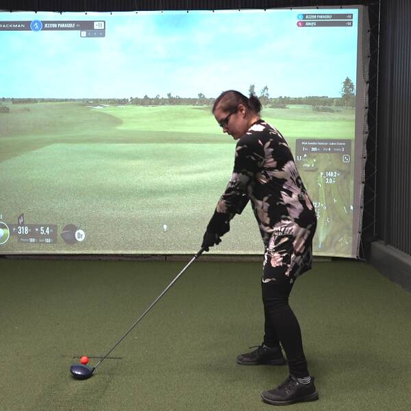 Jessica Hansols som till vardagas spelar golf i Dalsjö golfklubb står vid en golfsimulator i borlänge.