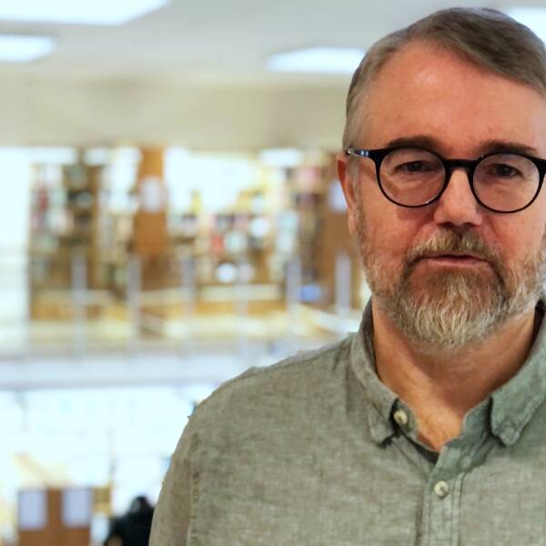 Porträttbild av Magnus Werner i en biblioteksmiljö.