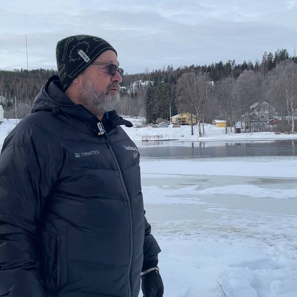 Håkan Håkansson står påklädd i vinterkläder och blickar ut över vattnet vid sjön Marmen i Sörfors utanför Sundsvall.