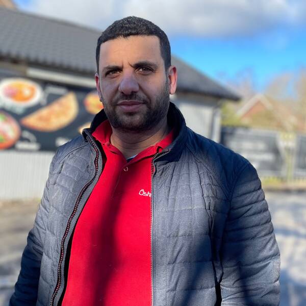 Kayed Qasmiyeh står utanför sin pizzeria och tittar in i kameran.