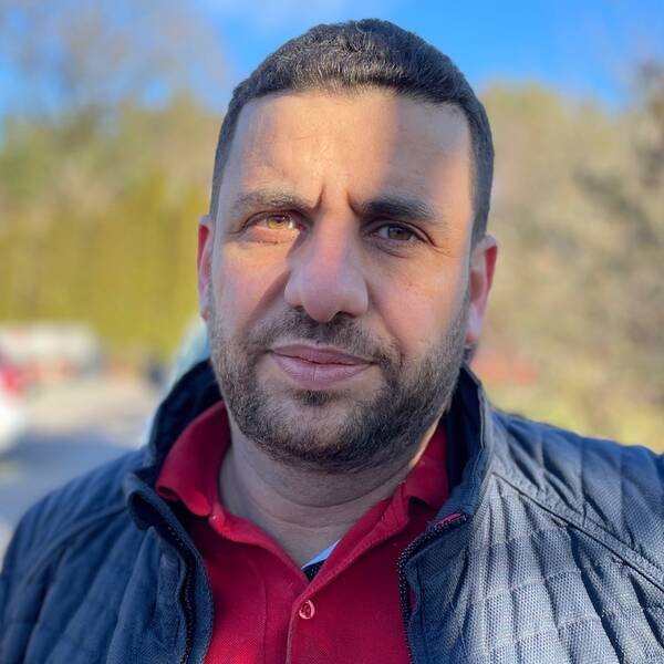 Kayed Qasmiyeh står utanför sin pizzeria och tittar in i kameran.