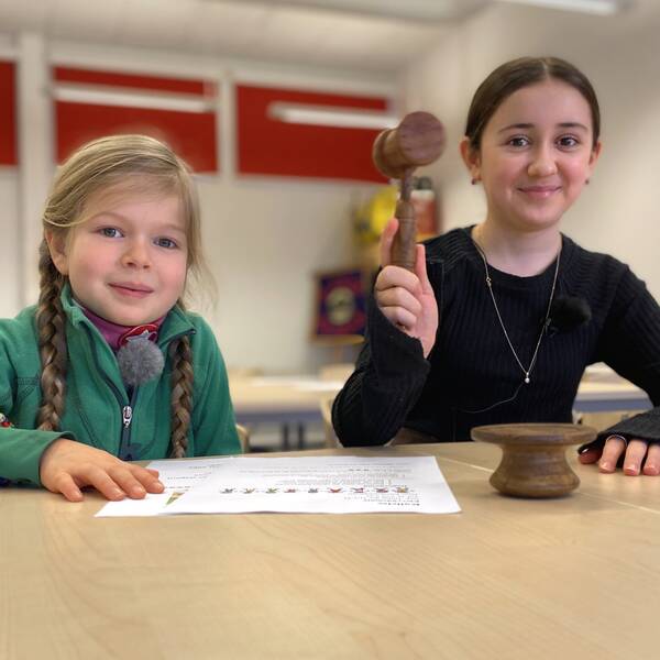 Saga Friis Johansen i grön tröja och Fatima Magomedova i svart tröja och med ordförandeklubba
