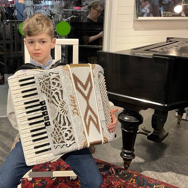 Mikola Mykytiuk från Ukraina spelar musik i butiken. På bilden sitter han med ett dragspel i famnen.