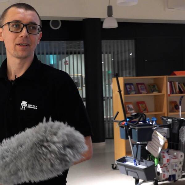 Volodymyr Ulianyk står bredvid en städvagn. Han har svart tröja och glasögon.
