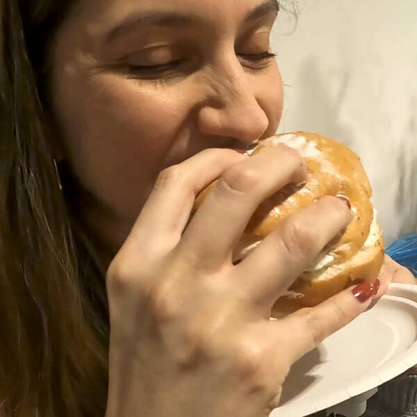 En kvinna äter en semla.