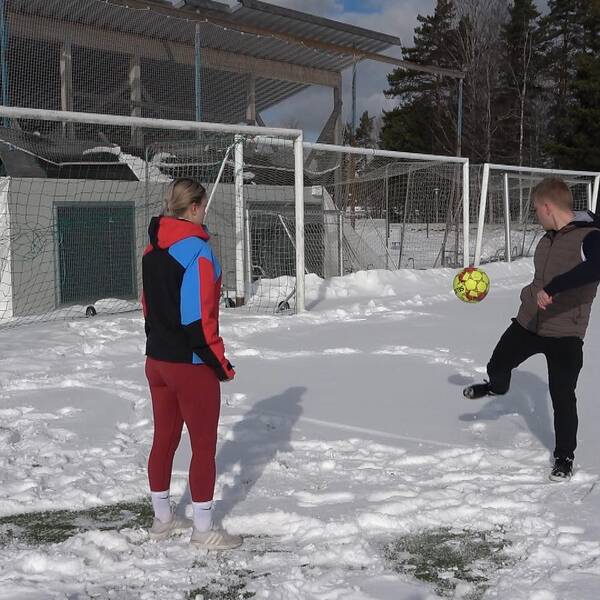 På bilden står Greta Söderberg och Linus Karlgren från fotbollsgymnasiet i Ljusdal och leker med en boll. De står på platsen där fotbollstältet stod förut, på Älvvallen. 