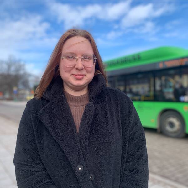 Halvbild på Mikaela Bech, glasögon, rödaktigt hår, ler med stängd mun.
