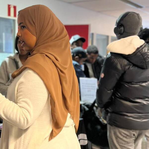 Personer står och minglar, både män och kvinnor.