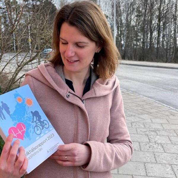 Redaktör för folkhälsorapporten 2023 i Region Stockholm visar upp rapporten