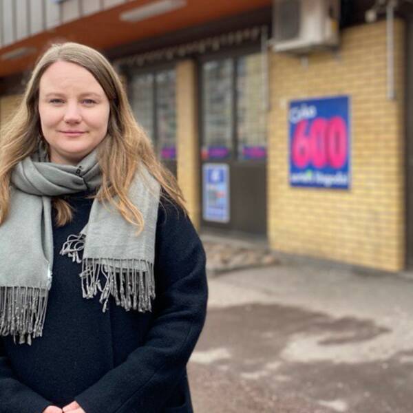 Stadsarkitekten Isabella Netz står vid ett lågt gult tegelhus som inhyser affärsverksamheter.