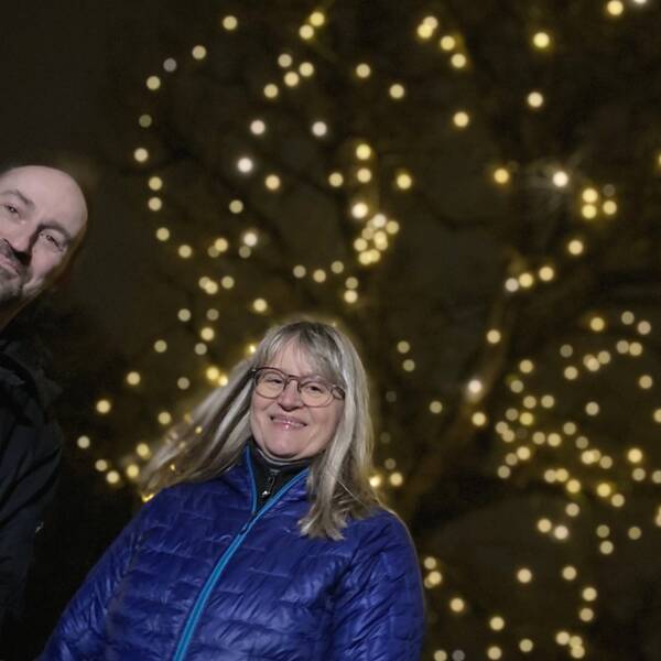 En och man en kvinna framför ett upplyst träd i Lundagård, Lund. Det är Susanne Åkesson och Johan Eklöf.