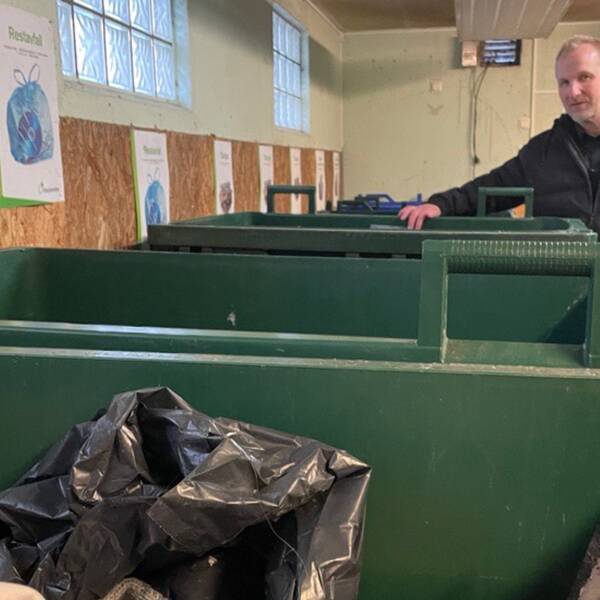 Per Gunnarsson, it- och digitaliseringsansvarig på SSAM, Södra Smålands avfall och miljö, står i ett soprum och håller i en grön soptunna.