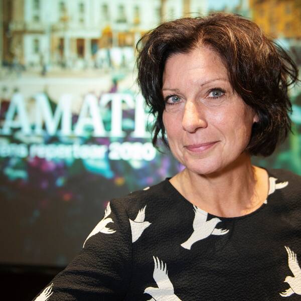 Maria Groop Russel framför skylt med bild på Dramaten.