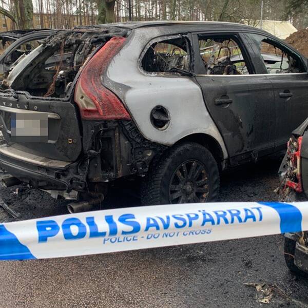 tre utrbrända bilar på en parkeringsplats