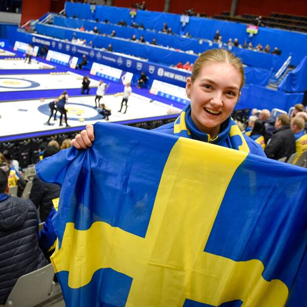 Moa Tjärnlund, åskådare, håller i en sverigeflagga på läktaren.
